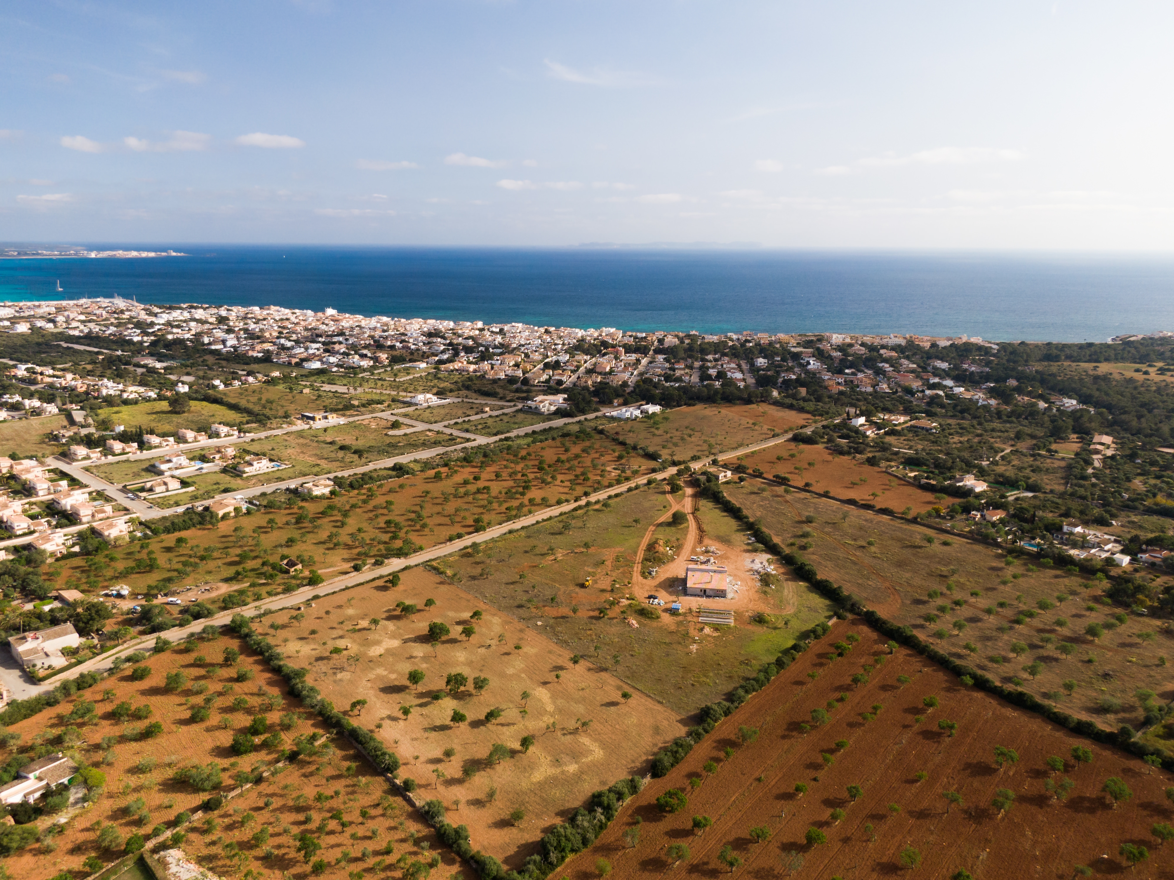 Aerial shot of beautiful blue sea and buildings in Mallorca Balearic Islands in Spain An aerial shot of beautiful blue sea and buildings in Mallorca Balearic Islands in Spain with a cloudy blue sky in the background